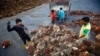 FILE - Workers collect palm oil fruits inside a palm oil factory in Salak Tinggi, outside Kuala Lumpur, Aug. 4, 2014. 
