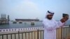 مرد اماراتی مقابل بندرگاه فجیره از خود سلفی می‌گیرد. 