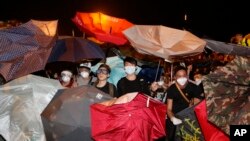 在香港政府总部外面，示威者用雨伞阻挡胡椒喷雾（2014年10月15日）