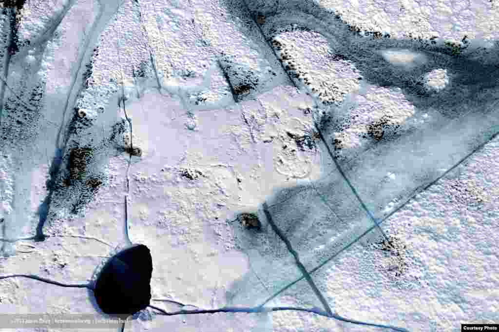 Di atas lapisan es Greenland, lumpur dan jelaga dari tempat yang jauh menyerap panas matahari dan mencair ke dalam es. (James Balog/Extreme Ice Survey)