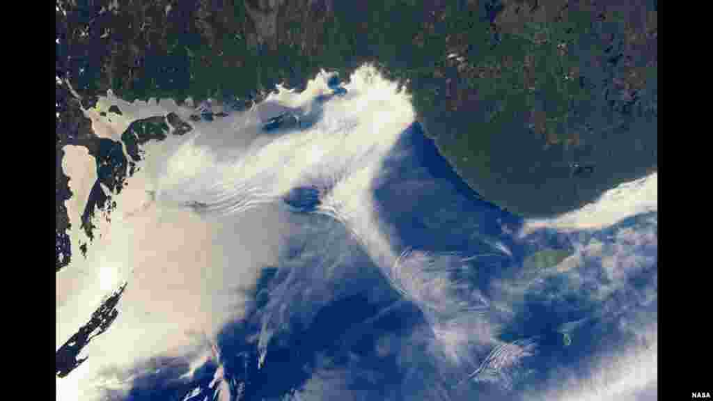 Dua fenomena atmosfer - gelombang gravitasi dan &#39;sunglint&#39; - tampak dalam foto Danau Superior di perbatasan AS-Kanada, yang diambil dari Stasiun Antariksa Internasional (ISS). 