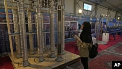FILE -A student looks at Iran's domestically built centrifuges in an exhibition of the country's nuclear achievements, in Tehran, Feb. 8, 2023.