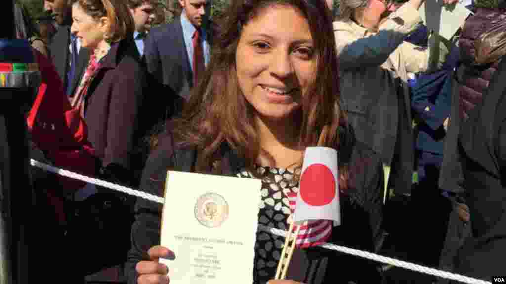 在华盛顿读书的学生Tiffany Leiva 手举请柬和美日国旗(美国之音张蓉湘拍摄)