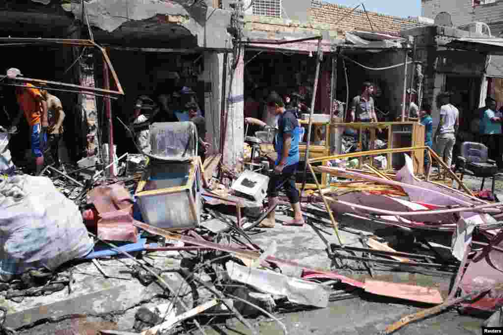 29일 이라크 바그다드 남부 바스라 지역 주민들이 차량 폭탄테러 현장을 살펴보고 있다.