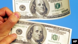 រូបឯកសារ៖ ក្រដាសប្រាក់ ១០០ ដុល្លារ (ខាងលើ) និង​ក្រដាសប្រាក់ ១០០ ដុល្លារ (ខាងក្រោម) ដែលត្រូវបានបោះពុម្ពនៅកូរ៉េខាងជើង ត្រូវបានបង្ហាញដោយសមាជិកសភាកូរ៉េខាងត្បូងម្នាក់ នៅវិមានសភា ក្នុងទីក្រុងសេអ៊ូល កូរ៉េខាងត្បូង ថ្ងៃទី២៣ ខែកុម្ភៈ ឆ្នាំ២០០៦។