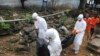 Health workers remove the body of Prince Nyentee, a 29-year-old man whom local residents said died of Ebola virus in Monrovia September 11, 2014. REUTERS/James Giahyue