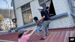 台湾花莲正在从被地震震得歪斜的建筑里救出一名女童。（2024年4月3日）