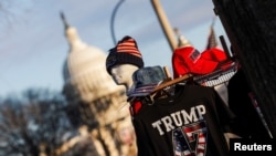 Футболка и кепки в поддержку избранного президента Дональда Трампа выставлены в сувенирном киоске на фоне Капитолийского холма
