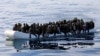 Migrants are seen in a rubber dinghy as they are rescued by the Libyan coast guard in the Mediterranean Sea off the coast of Libya, Jan. 15, 2018. 
