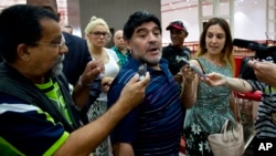 La légende du football argentin Diego Armando Maradona parle à des journalistes à l'aéroport sur son chemin pour prendre un avion de départ à La Havane, Cuba, le lundi 12 janvier 2015. 