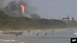 Ljudi plivaju u blizini rafinerije nafte El Palito u blizini Puerto Cabella, Venecuela, ponedjeljak, 29. januara 2024. (AP Photo/Matias Delacroix)