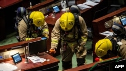 Members of the fire brigade perform tests in the main chamber of the Legislative Council after pan-democrat lawmakers hurled an odorous liquid during the third reading of the national anthem bill in Hong Kong on June 4, 2020.