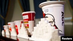 A 64-ounce drink is displayed alongside other soft drink cup sizes n New York, May 31, 2012. 