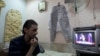 Syrian flower shop owner watches live joint United Nations press conference, Damascus, Sept. 14, 2013.