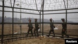 South Korean soldiers patrol along a barbed-wire fence, near the demilitarized zone (DMZ) which separates the two Koreas in Paju, north of Seoul, April 5, 2013. 