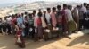 FILE - Rohingya refugees stand in a queue to collect aid supplies in Kutupalong refugee camp in Cox's Bazar, Bangladesh, Jan. 21, 2018.