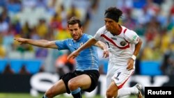 우르과이의 크리스천 스투아니(왼쪽) 선수와 코스타리카의 크리스천 볼라노스 선수가 14일 치러진 경기도중 공을 빼앗기 위해 치열한 몸싸움을 벌이고 있다.