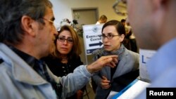 خانواده های ایرانی الاصل(سمت چپ) که بستگانشان در فرودگاه لس آنجلس امکان خروج نیافتند، با یکی از مقامات گفت و گو می کنند. 