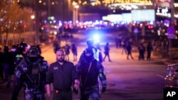 2024年3月22日，俄罗斯莫斯科西部的克罗库斯城音乐厅附近，俄罗斯联邦国家近卫军的军人帮助一名男子离开该地区。