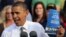 President Barack Obama holds up a copy of jobs plan during a joint campaign appearance with Vice President Joe Biden (not seen) at Triangle Park in Dayton, Ohio, October 23, 2012.