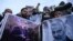 Protesters shout slogans against the United States and Israel as they hold posters with the image of top Iranian commander Qasem Soleimani, who was killed in a US airstrike in Iraq, and Iranian President Hassan Rouhani during a demonstration in the…