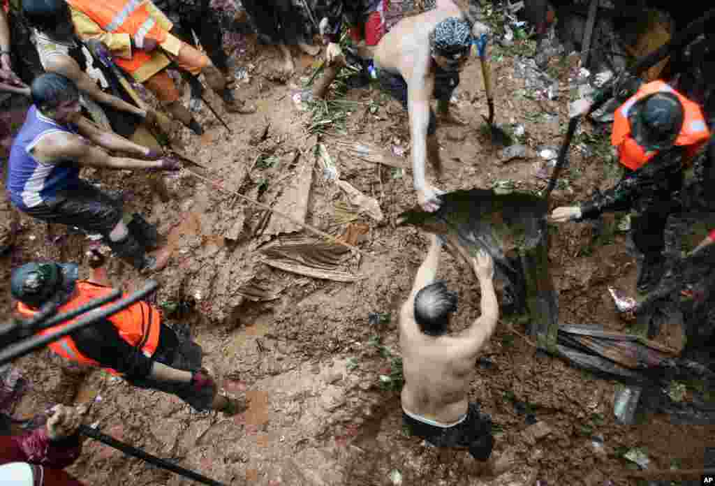 Philippine rescuers dig for survivors where four homes collapsed in a landslide incident in Quezon City, north of Manila, Philippines, August 7, 2012. 