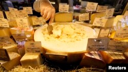 کارمند يک فروشگاه مواد غذايی در سن پترزبورگ، پنيرهايی را پشت ويترين می چيند -- ۲۰ مرداد (۱۱ اوت)