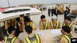 Airport personnel load a coffin into an ambulance at the Noi Bai airport, Nov. 27, 2019 in Hanoi, Vietnam. The bodies of 16 of the 39 Vietnamese found dead in a truck in Britain last month, have been repatriated to their homeland.