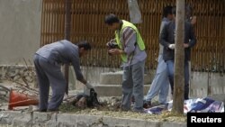 Afghan policemen investigate at the site of suicide attack in Kabul, September 8, 2012. 