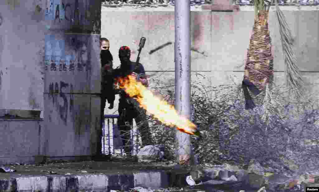 Seorang demonstran anti-Presiden Morsi, melempar bom Molotov ke arah polisi anti huru hara, dalam bentrokan di kota Port Said, kawasan terusan Suez, Mesir.