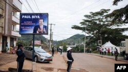 FILE - Police officers stand in front of the polling station where incumbent Cameroon President Paul Biya, is expected to vote, in Yaounde, Oct. 7, 2018. Biya's election win remain disputed by the opposition. 