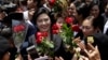 FILE - Thailand's former Prime Minister Yingluck Shinawatra, center, receives flowers from her supporters at the Supreme Court after making her final statements in a trial on a charge of criminal negligence in Bangkok, Thailand, Aug. 1, 2017. 