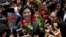 FILE - Thailand's former Prime Minister Yingluck Shinawatra, center, receives flowers from her supporters at the Supreme Court after making her final statements in a trial on a charge of criminal negligence in Bangkok, Thailand, Aug. 1, 2017. 
