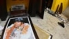 A broken portrait of Bolivia's former President Evo Morales is on the floor of his private home in Cochabamba, Bolivia, after hooded opponents broke into the residence Nov. 10, 2019. Morales resigned Sunday. 