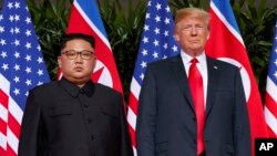도널드 트럼프 미국 대통령과 김정은 북한 국무위원장이 지난 6월 싱가포르에서 열린 첫 미-북 정상회담에서 나란히 서있다.