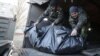 Ukrainian soldiers unload the bodies of their comrades killed in Debaltseve at a checkpoint near Horlivka on February 24.