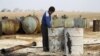 FILE - A youth works at a makeshift oil refinery in the countryside south of Idlib, Syria. 