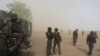FILE - Cameroonian soldiers from the Rapid Intervention Brigade stand guard amidst dust kicked up by a helicopter in Kolofata, Cameroon.