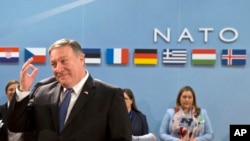 FILE - U.S. Secretary of State Mike Pompeo, left, waits for the start of the North Atlantic Council at NATO headquarters in Brussels, April 27, 2018. 