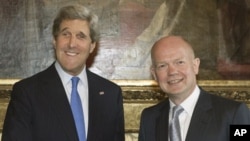 Menlu Inggris William Hague (kanan) menyambut Menlu AS John Kerry dalam pertemuan di London (10/4).