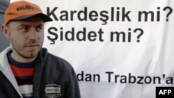 «Եղբայրություն, թե՞ բռնություն» կարգախոսով պաստառի մոտ կանգնած ակտիվիստ, Տրապիզոն, 2007 թվականի հունվար (արխիվային լուսանկար)