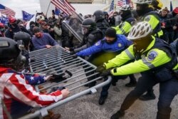 FILE - Supporters of President Donald Trump try to break through a police barrier at the Capitol in Washington, Jan. 6, 2021.