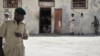 FILE - Prison guards stand outside a cell in Mogadishu Central Prison, December 10, 2013.