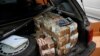 FILE - Money is seen piled in the back of a car in the Democratic Republic of Congo's capital Kinshasa.