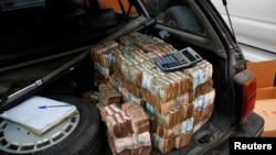 FILE - Money is seen piled in the back of a car in the Democratic Republic of Congo's capital Kinshasa.