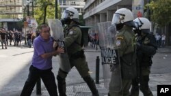 A riot policeman pushes an elderly protester with his shield during clashes during the 24-hour nationwide general strike in Athens, October 18, 2012.