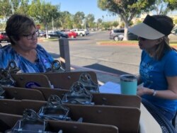 Heidi Hu, right, meets with a Field Team 6 trainer before she registers young college students to vote Democrat for the re-election of US Rep. Katie Porter. (Carolyn Presutti/VOA News)