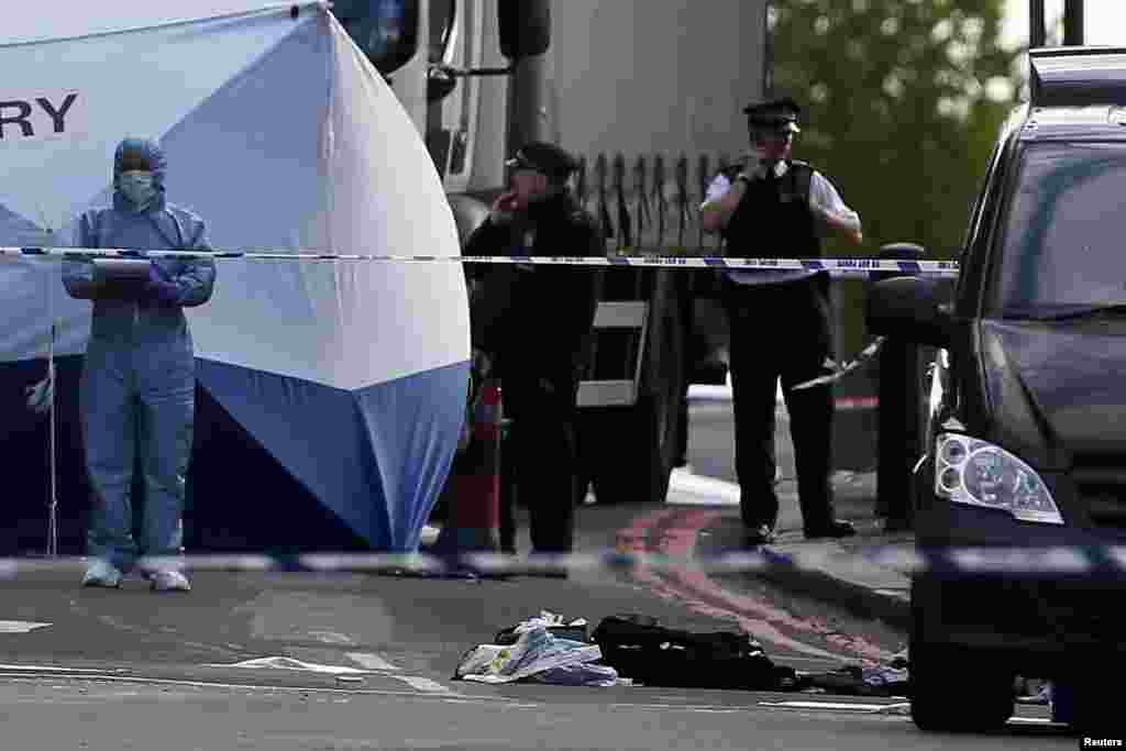 A police forensics officer investigates a crime scene where one man was killed in Woolwich, London, May 22, 2013.