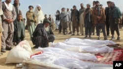 阿富汗平民聚集在冲突中死亡者周围。
