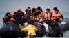Sejumlah migran yang berupaya untuk mencapai Inggris dengan menyeberangi Selat Inggris, naik ke atas perahu karet yang berangkat dari wilayah Wimereux, Prancis, pada 4 September 2024. (Foto: Reuters/Benoit Tessier)